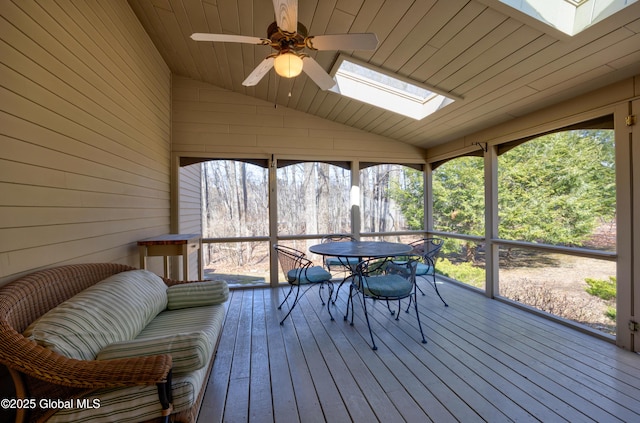 sunroom with lofted ceiling with skylight and a ceiling fan