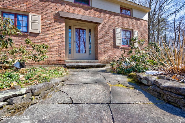 property entrance featuring brick siding