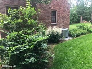 view of property exterior featuring a lawn and central AC