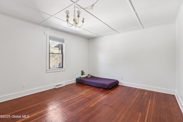 interior space with visible vents, baseboards, an inviting chandelier, and hardwood / wood-style floors