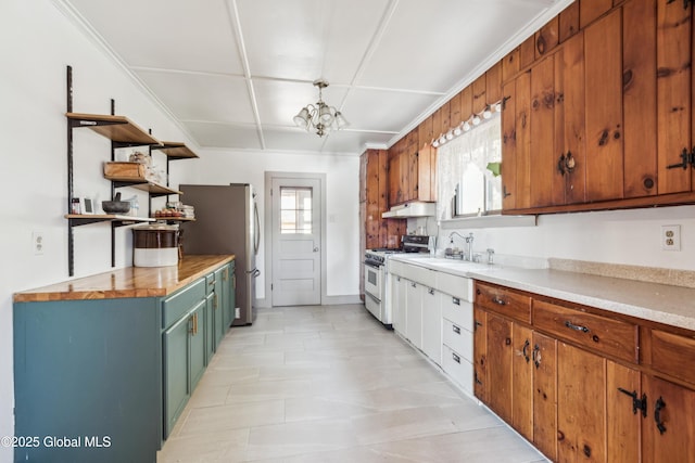 kitchen featuring a notable chandelier, white gas stove, a sink, open shelves, and under cabinet range hood