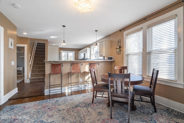 dining area with stairs, baseboards, and wood finished floors