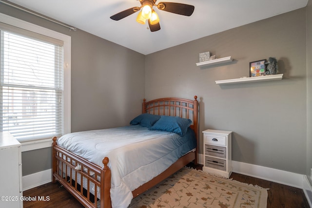 bedroom featuring a ceiling fan, baseboards, and wood finished floors