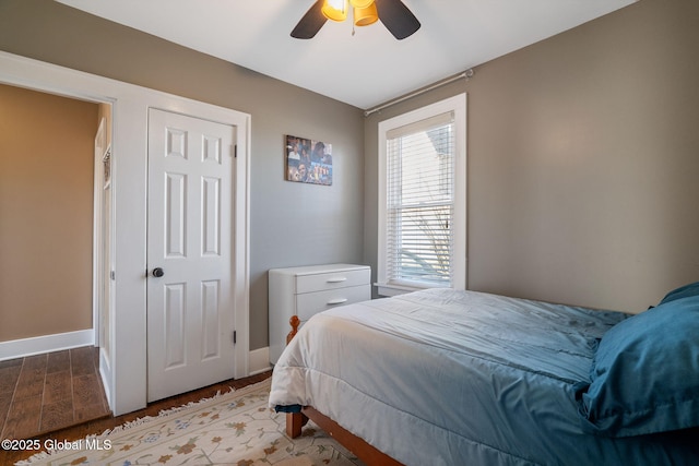 bedroom featuring ceiling fan, baseboards, and wood finished floors