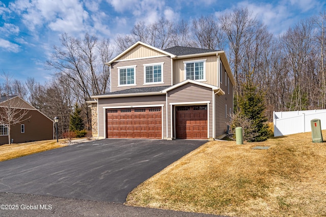 view of front of property featuring aphalt driveway, a front yard, an attached garage, and fence