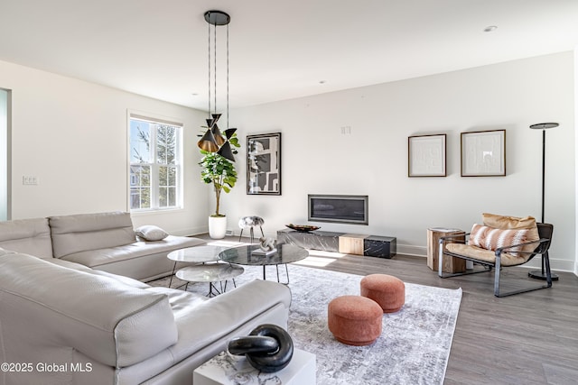 living room with visible vents, baseboards, and wood finished floors