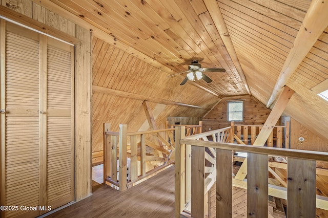 corridor with wood finished floors, lofted ceiling, wood ceiling, wood walls, and an upstairs landing