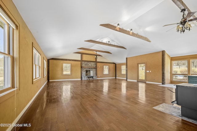 unfurnished living room featuring lofted ceiling, hardwood / wood-style flooring, a ceiling fan, and baseboards