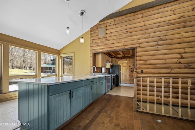 kitchen featuring a peninsula, a sink, hanging light fixtures, light countertops, and stainless steel dishwasher