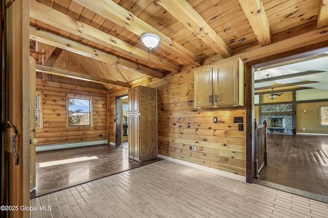 unfurnished room featuring beam ceiling, a stone fireplace, ceiling fan, and hardwood / wood-style floors