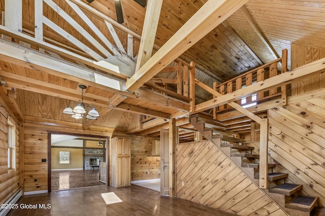 stairs with hardwood / wood-style floors, wood ceiling, wood walls, a baseboard heating unit, and a chandelier