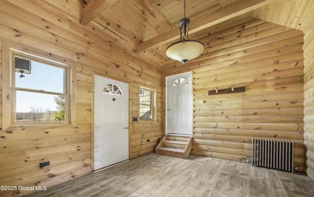 foyer entrance featuring beam ceiling, radiator heating unit, wood finished floors, and wooden ceiling