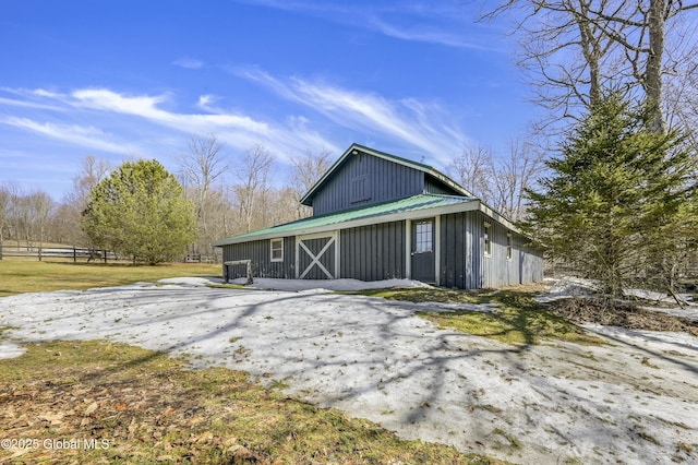 view of property exterior featuring metal roof, an outbuilding, a barn, and board and batten siding