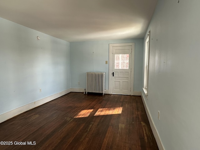 interior space with radiator, baseboards, and dark wood-style flooring