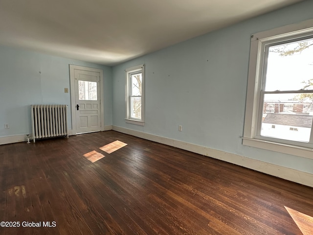 interior space with dark wood-style floors, radiator, and baseboards