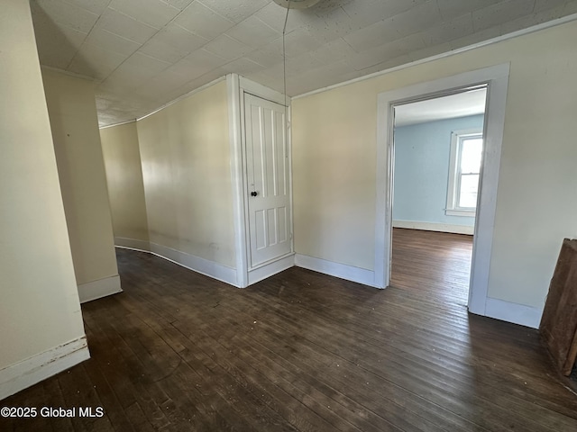 additional living space featuring baseboards and hardwood / wood-style floors