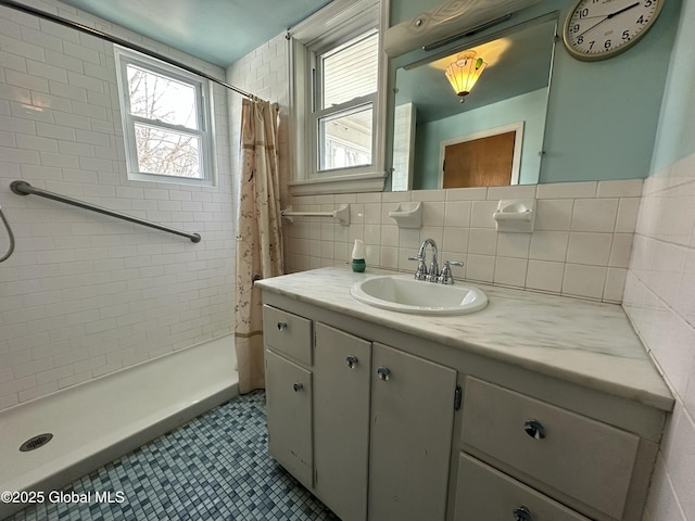 full bath featuring a stall shower, tile walls, tile patterned flooring, decorative backsplash, and vanity