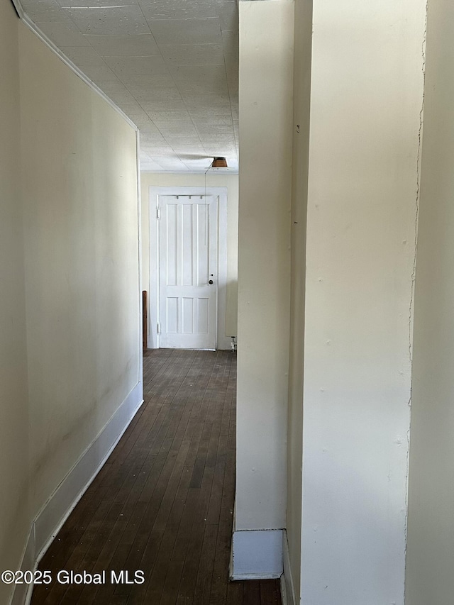 hall with dark wood-style floors and baseboards