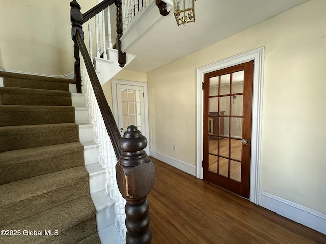 staircase with baseboards and wood finished floors