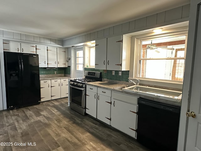 kitchen featuring black appliances, white cabinets, light countertops, dark wood-type flooring, and backsplash