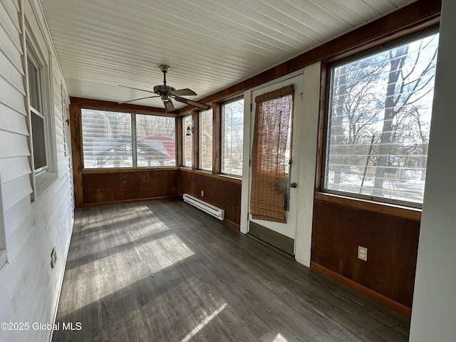 unfurnished sunroom featuring a baseboard heating unit and ceiling fan