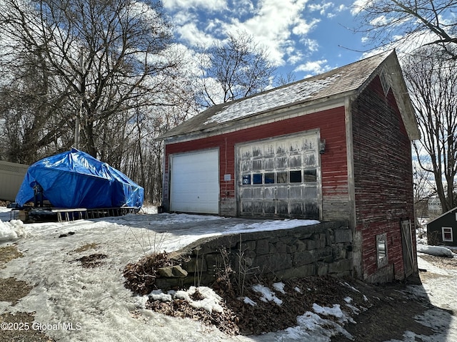 snow covered garage with a garage