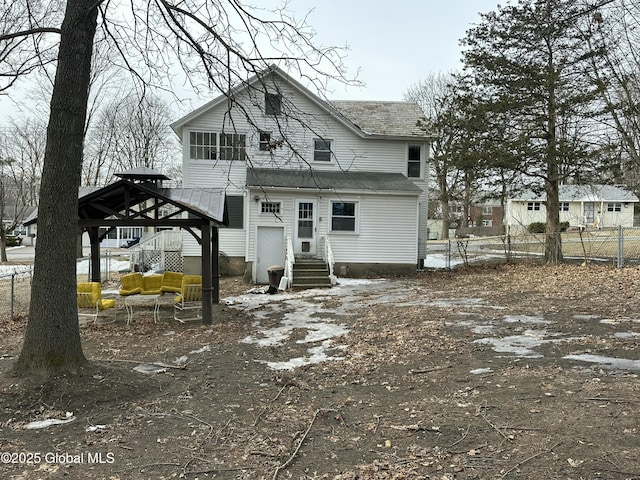 rear view of house with a gazebo, fence, and entry steps