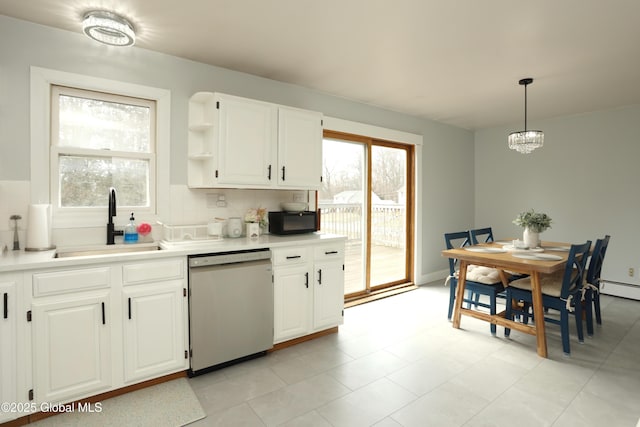 kitchen featuring black microwave, light countertops, stainless steel dishwasher, white cabinetry, and a sink