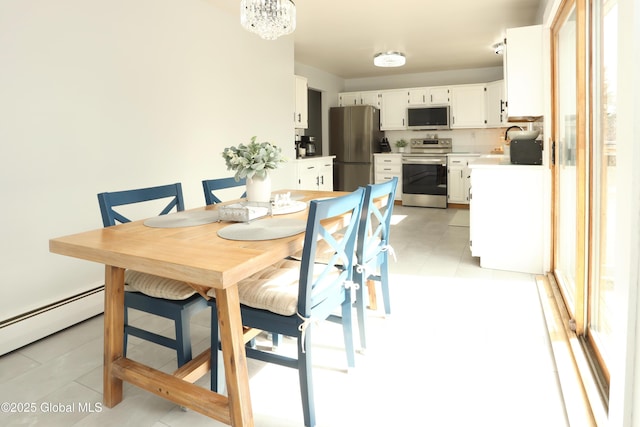 dining space featuring light tile patterned floors, a notable chandelier, and baseboard heating