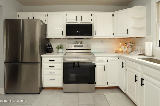 kitchen with open shelves, backsplash, appliances with stainless steel finishes, and light countertops