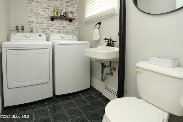 bathroom featuring washing machine and dryer, toilet, and a baseboard radiator