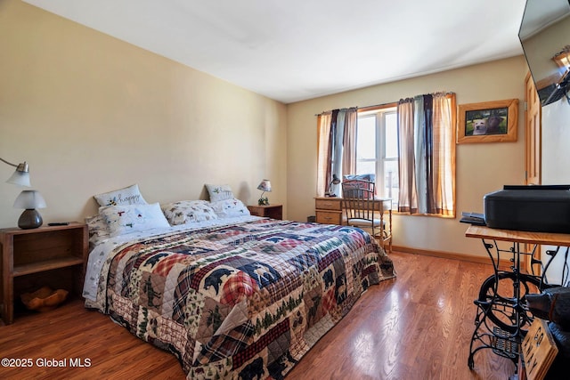 bedroom featuring baseboards and wood finished floors