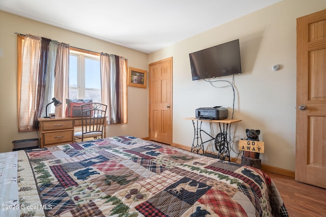 bedroom featuring baseboards and wood finished floors