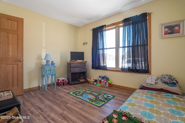 bedroom featuring wood finished floors and baseboards