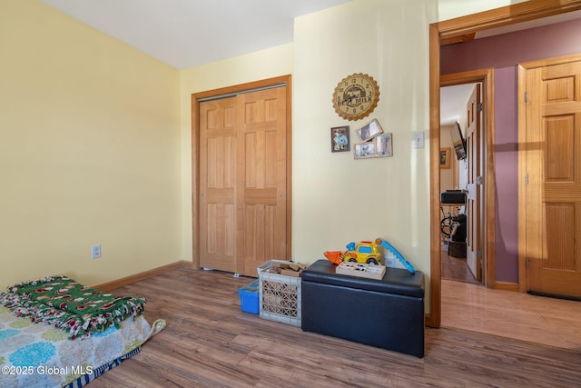 bedroom with a closet, baseboards, and wood finished floors