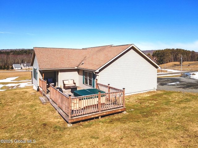 back of house featuring an outdoor living space, a yard, roof with shingles, and a wooden deck