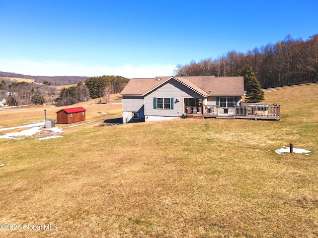 back of house with a lawn, a wooden deck, a storage shed, and an outdoor structure