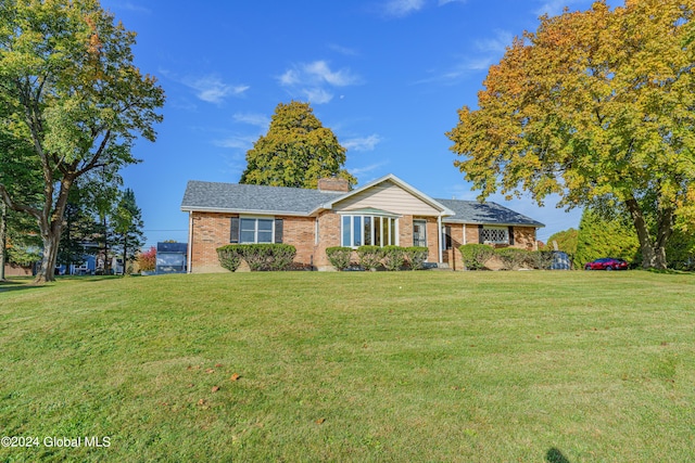 ranch-style home featuring a front lawn, brick siding, and a chimney