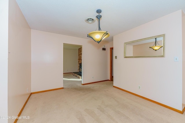 carpeted spare room featuring visible vents and baseboards