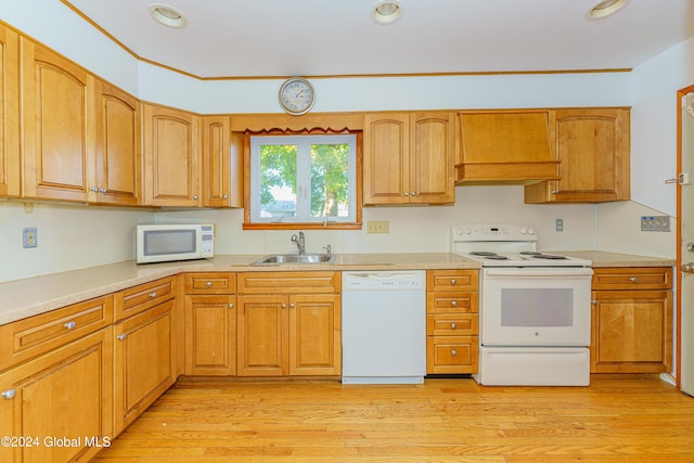 kitchen featuring white appliances, light wood-style flooring, light countertops, and a sink