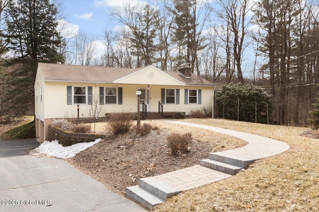 ranch-style home with driveway and a chimney