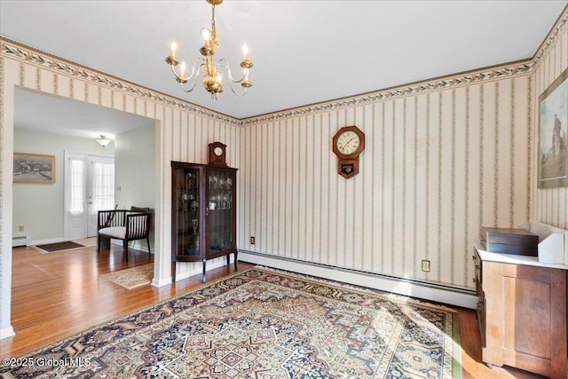 dining area with wallpapered walls, an inviting chandelier, wood finished floors, and baseboard heating