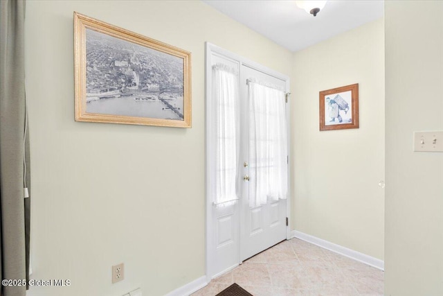 entrance foyer featuring light tile patterned flooring and baseboards