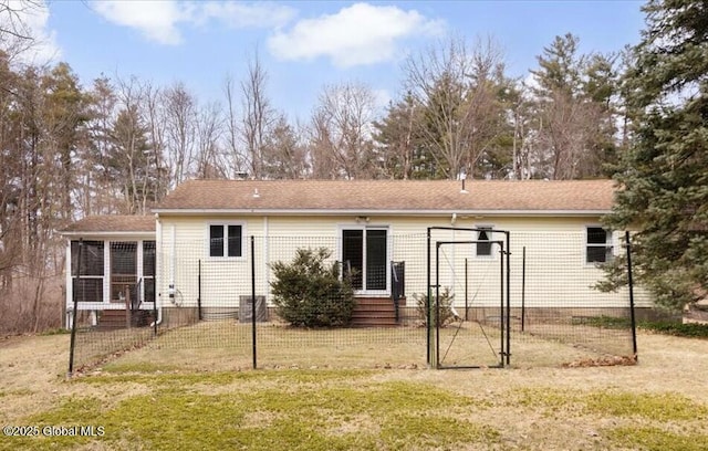 rear view of house with fence, a lawn, a sunroom, and entry steps