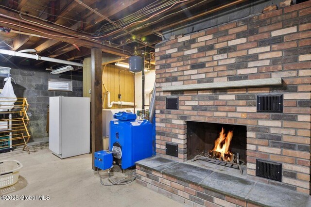 unfinished below grade area with visible vents, a fireplace, and freestanding refrigerator