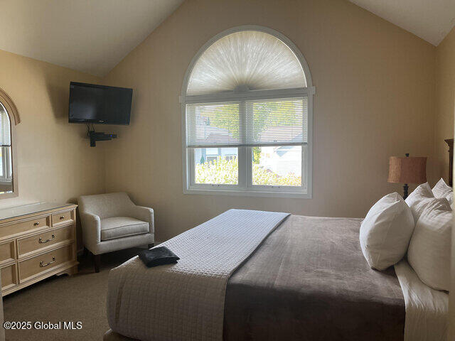 carpeted bedroom with vaulted ceiling