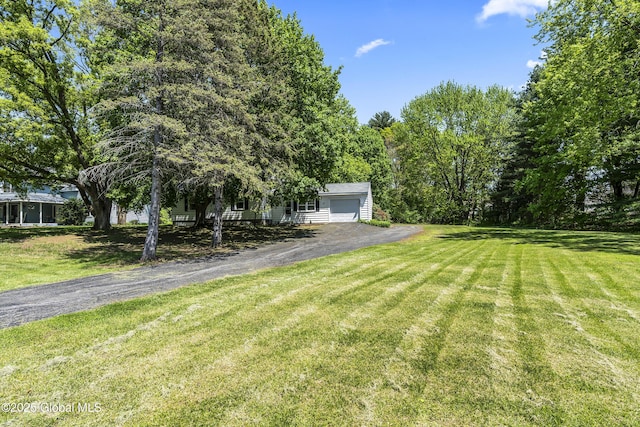 68 Wemple Rd, Bethlehem, NY 12054 - view of front of property with asphalt driveway, a garage, and a front lawn