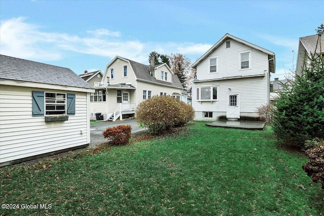 rear view of house featuring a yard, central air condition unit, and a patio