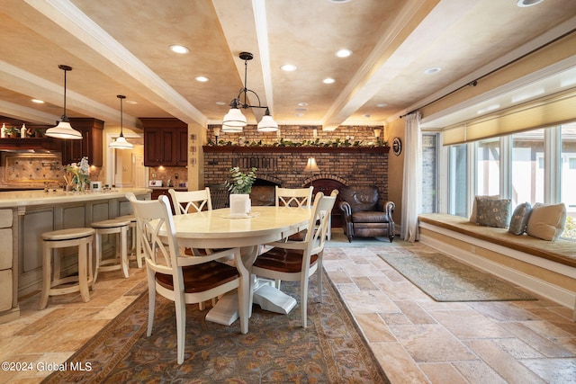 dining room featuring beamed ceiling, ornamental molding, recessed lighting, a fireplace, and stone tile flooring