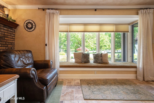 sitting room with stone tile floors, baseboards, and a wealth of natural light